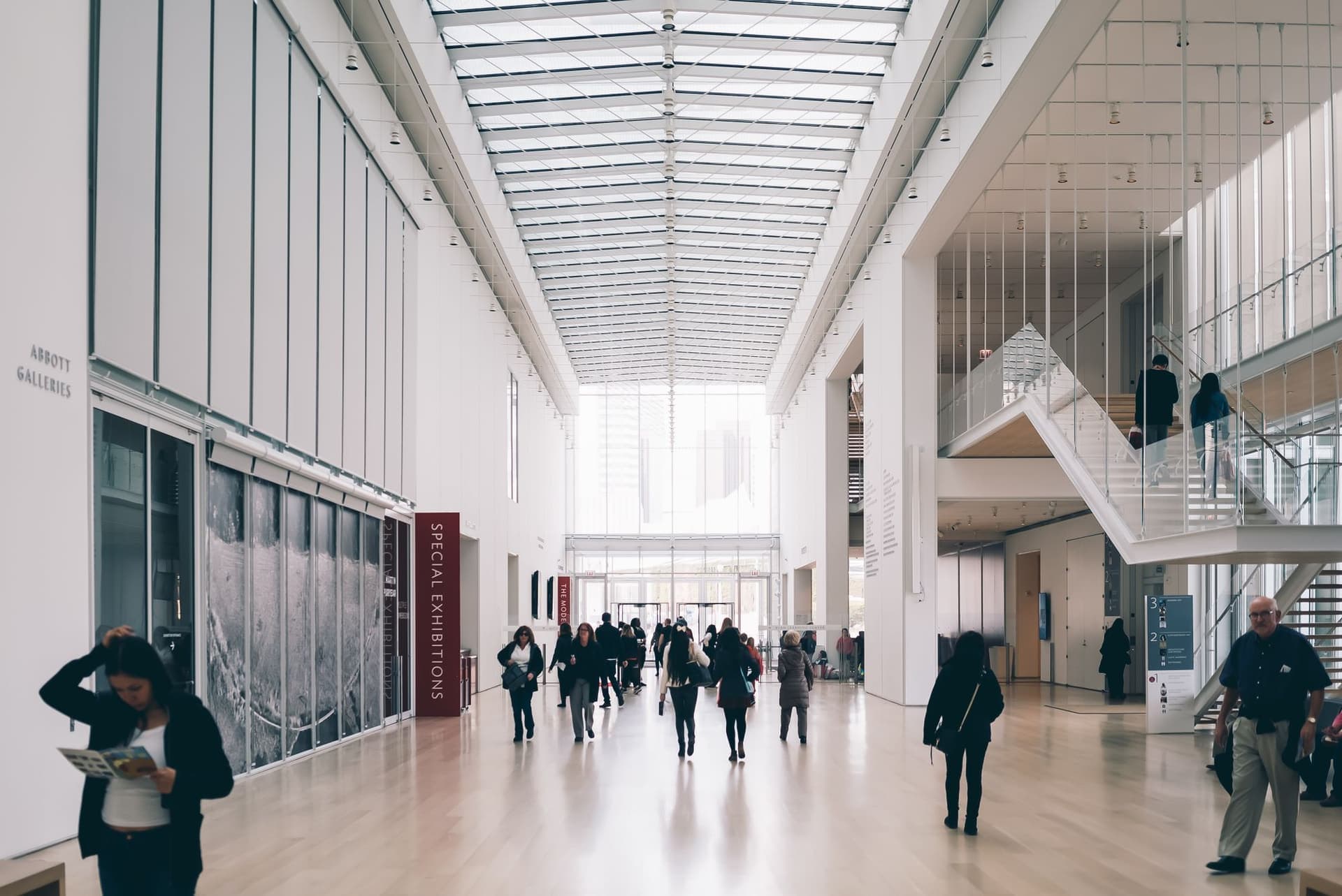 A white gallery hall with visitors